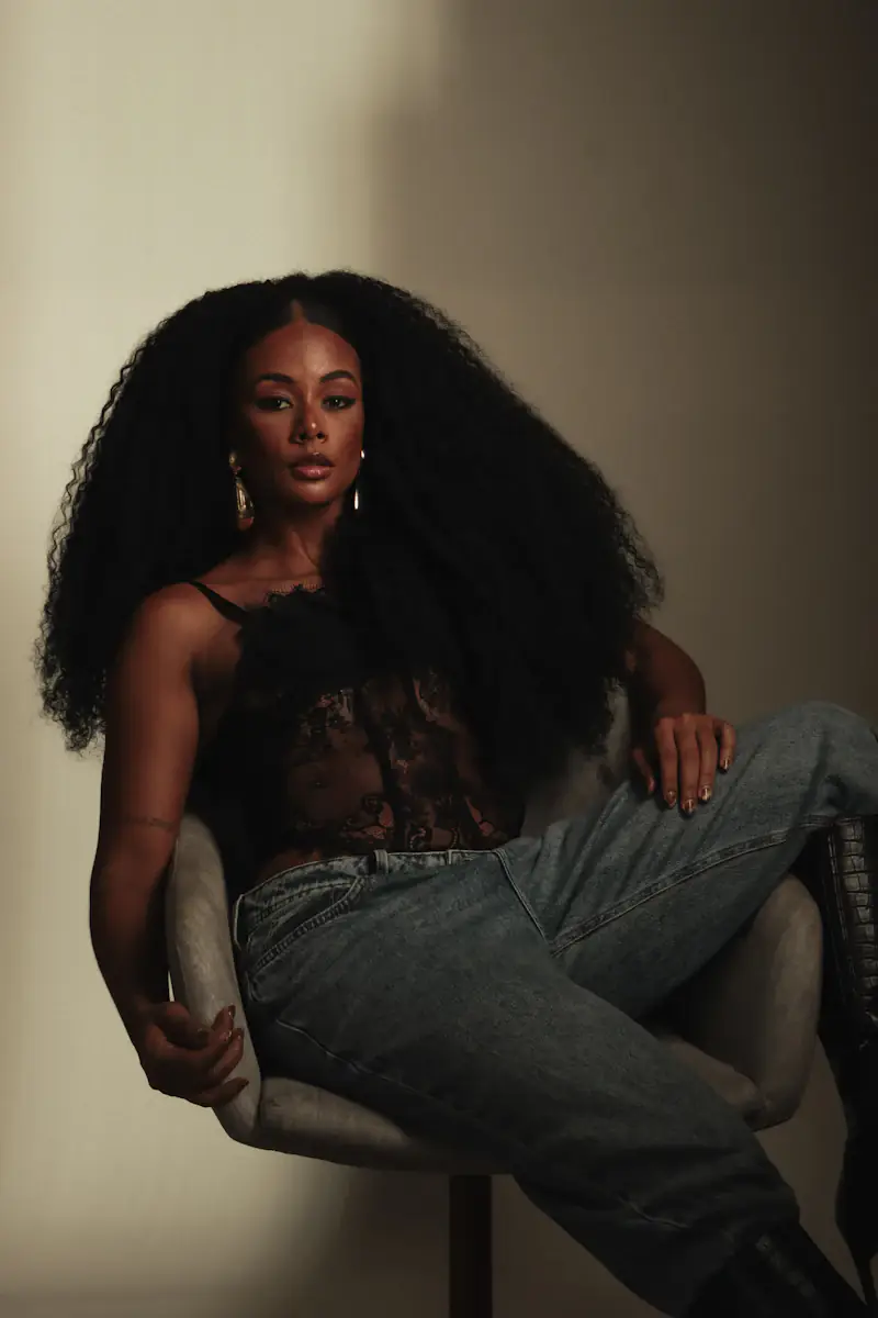 Mulher sentada, com cabelo cacheado muito comprido
